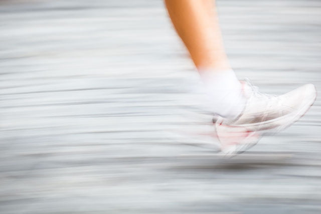 Motion blurred runner's feet in a city environment - running mar